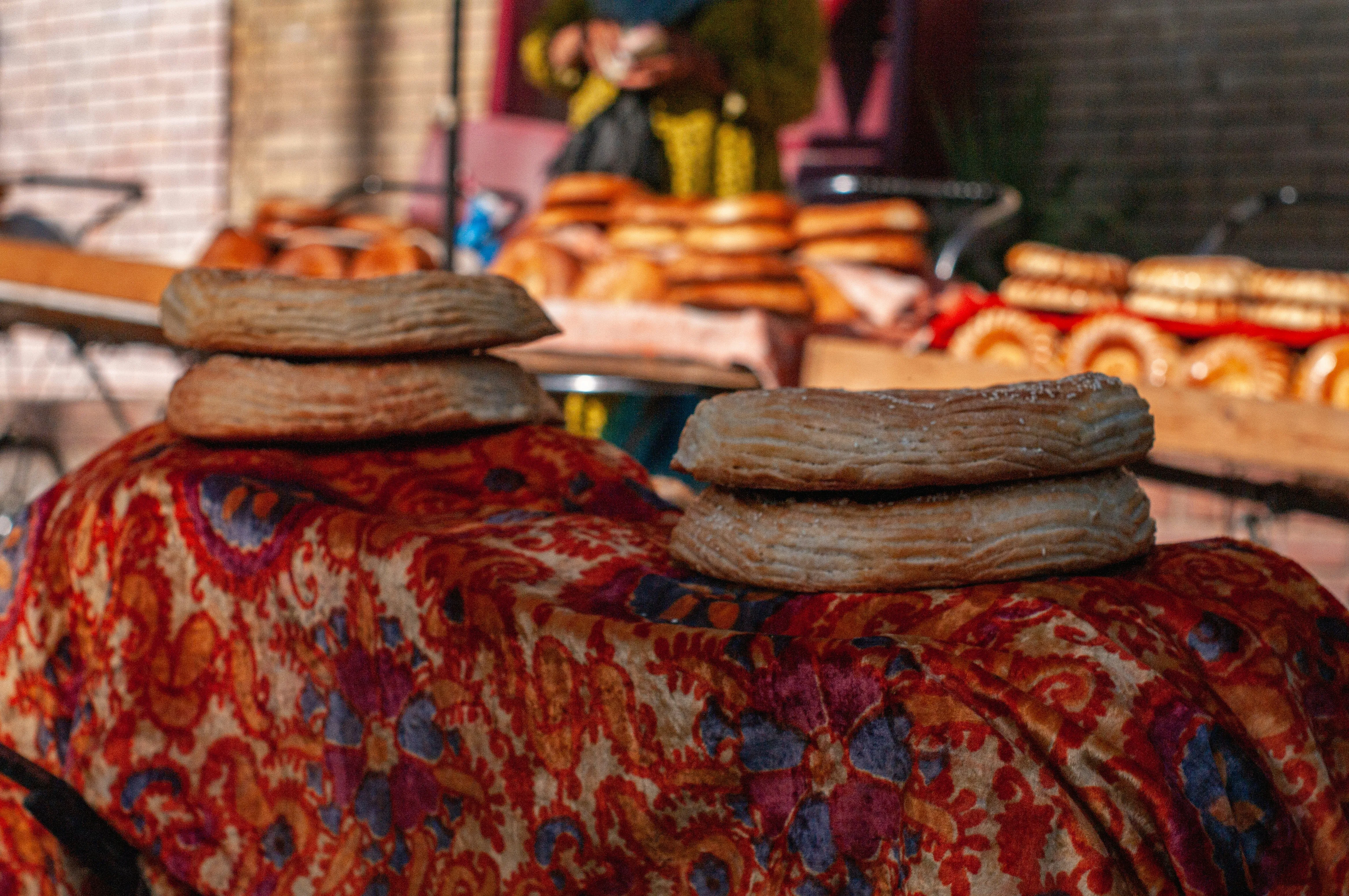 Traditional Uzbek flatbread on an embroidered cloth at a market stall