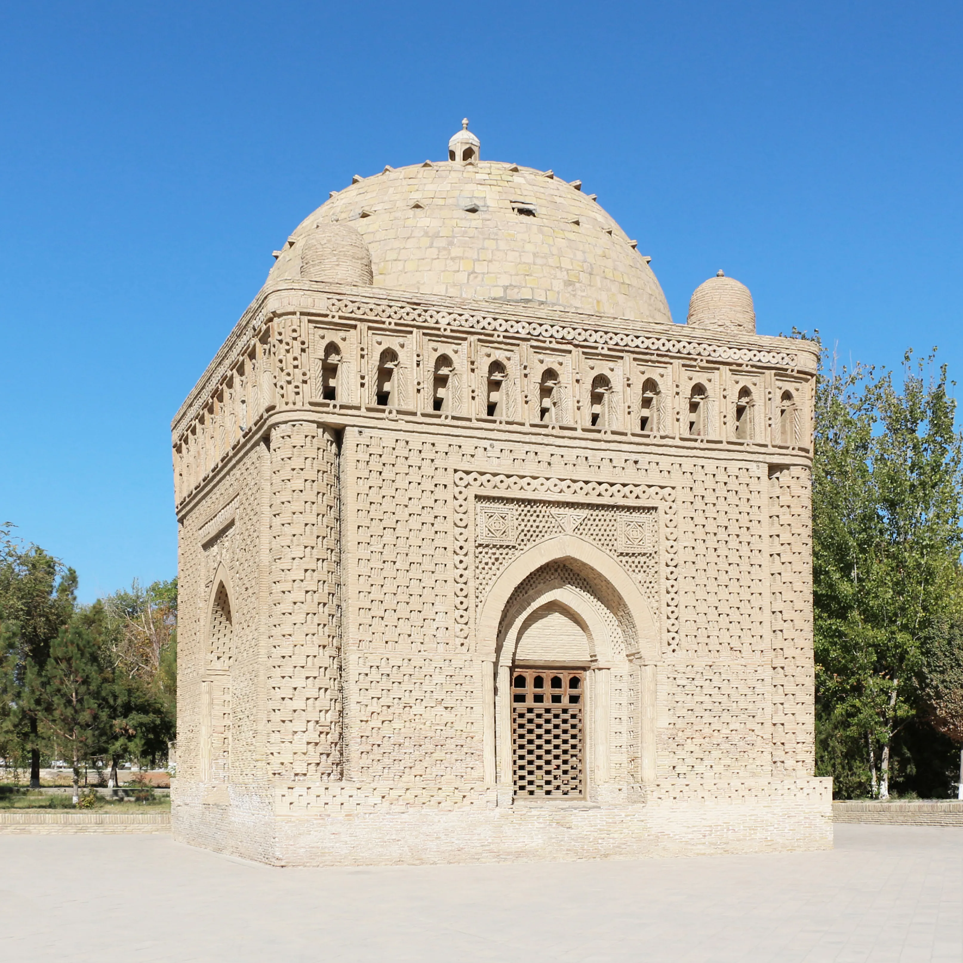 The Samanid Mausoleum in Bukhara under a clear blue sky
