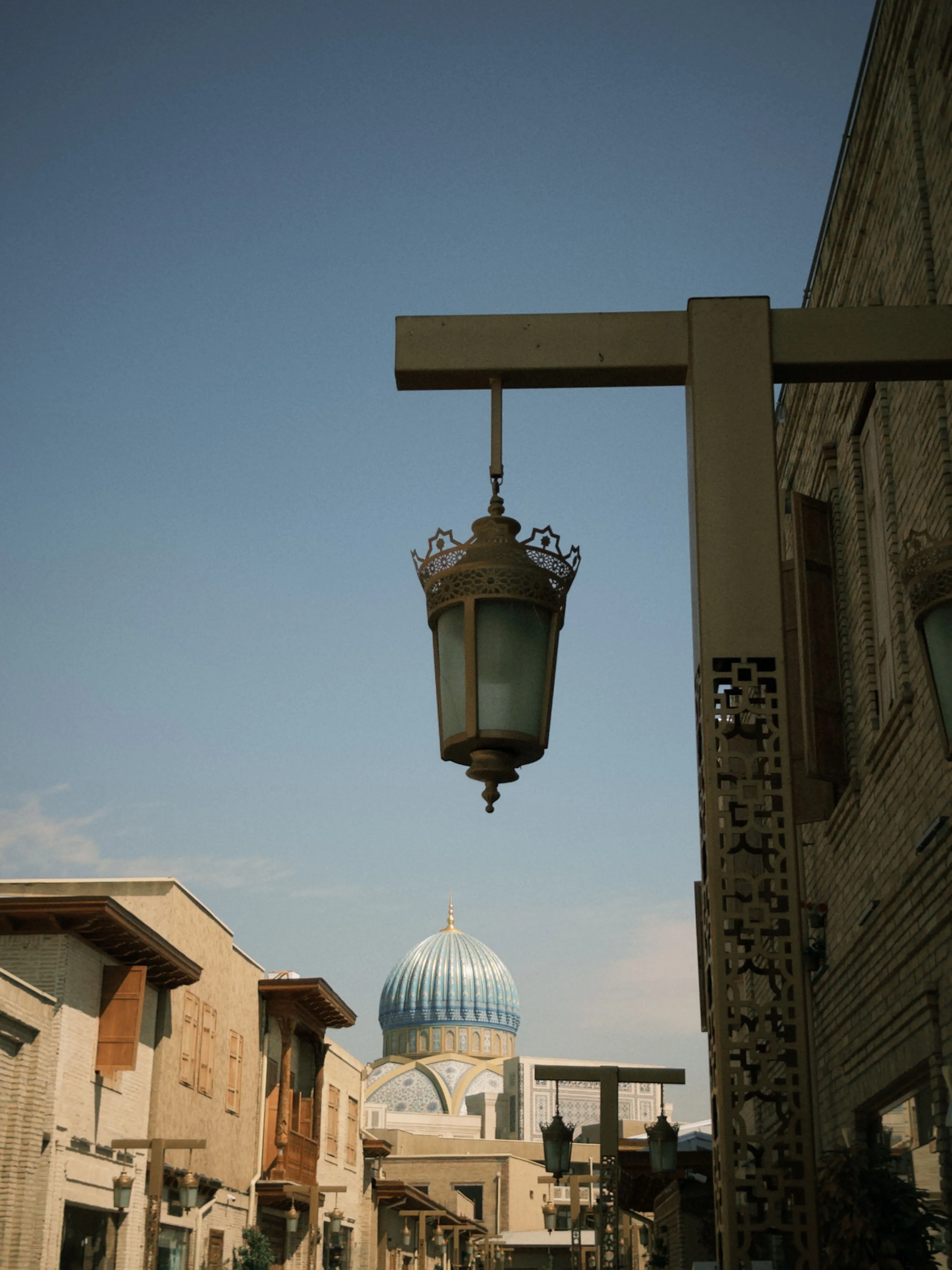 An ornate street lantern with a blue ribbed dome in the background